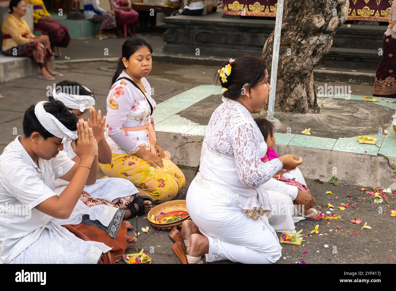 Una famiglia prega durante la cerimonia Kuningan, il tempio pura Gunung Sari, Denpasar, Bali, Indonesia, Asia Foto Stock