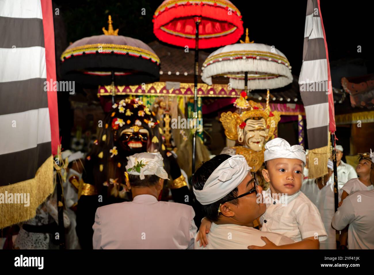 Un uomo con suo figlio Barong Landung burattini al santuario, cerimonia Kuningan, tempio pura Gunung Sari, Denpasar, Bali, Indonesia, Asia Foto Stock