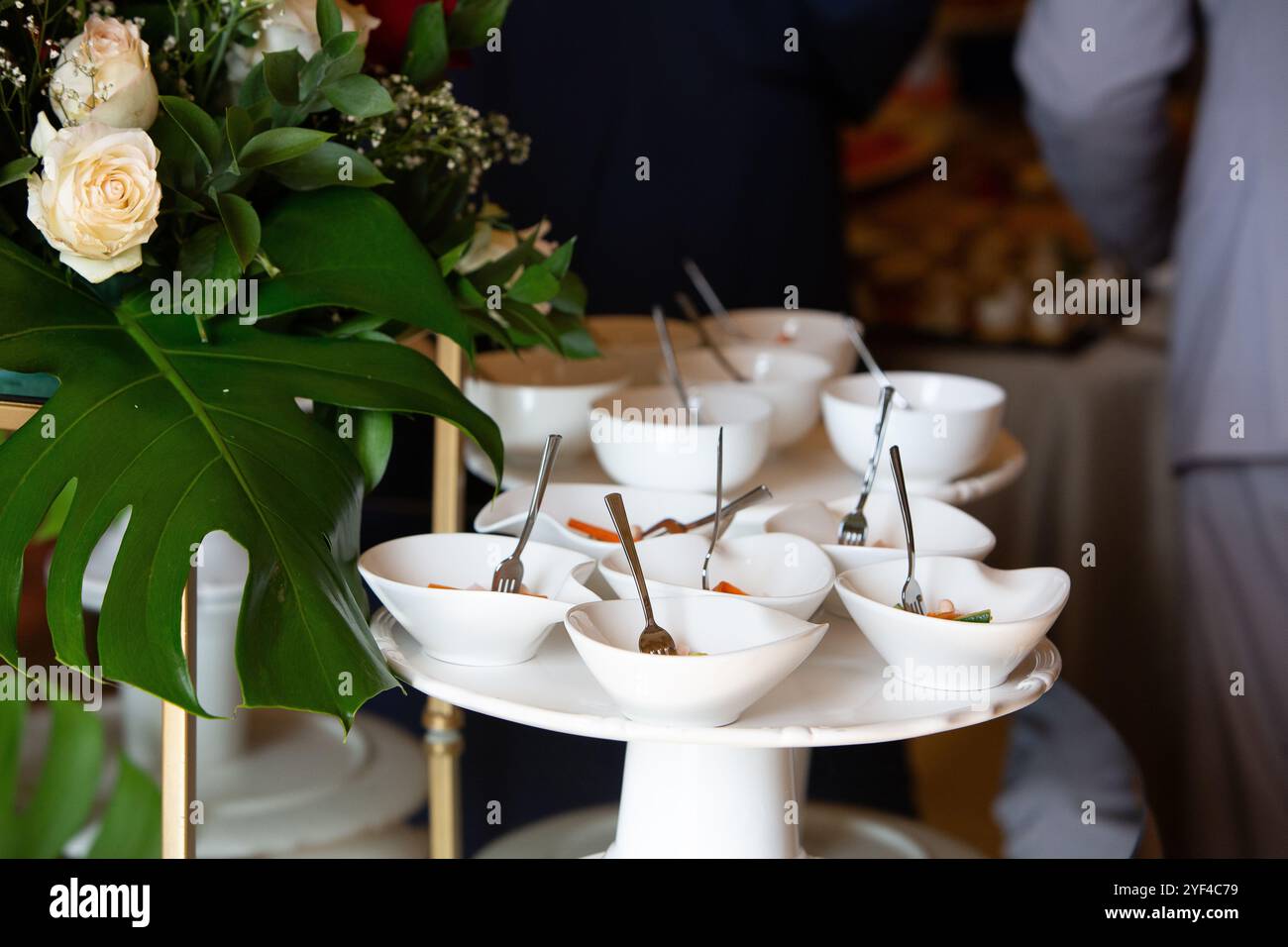 Piccole ciotole bianche contenenti antipasti sono esposte su un piedistallo durante un evento con catering Foto Stock