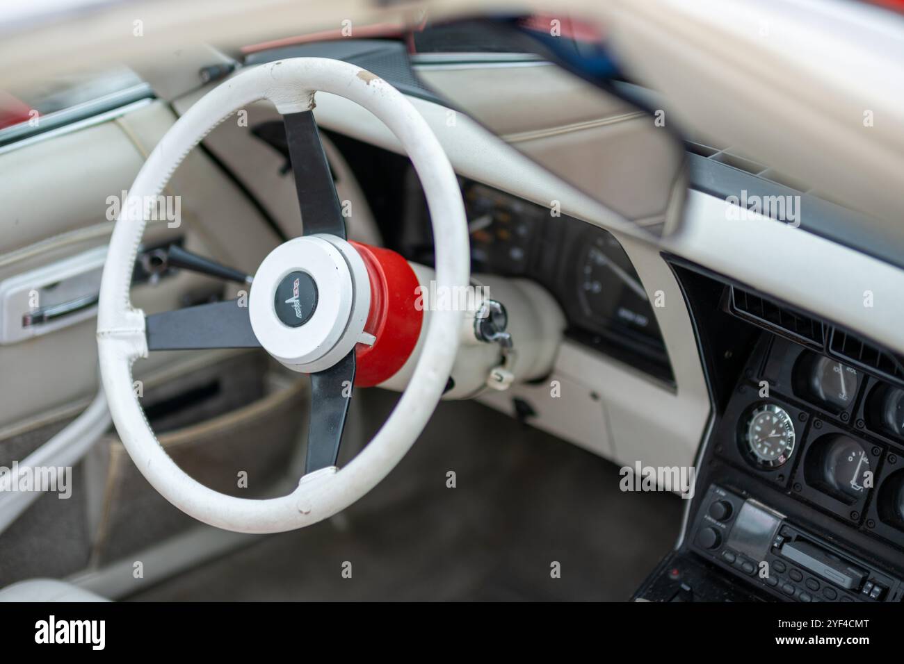 Interni di auto d'epoca con volante bianco esclusivo, cruscotto classico e indicatori retrò, che mostrano un design automobilistico senza tempo e un fascino nostalgico. Foto Stock