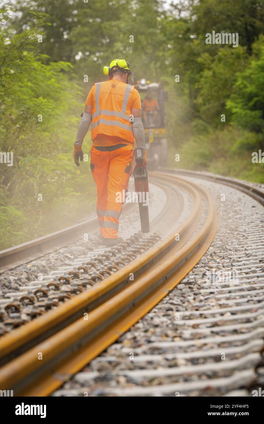 Operaio edile in indumenti protettivi che cammina accanto a binari ferroviari nella nebbia, costruzione di binari, Hermann Hessebahn, Calw, Foresta Nera, Germa Foto Stock