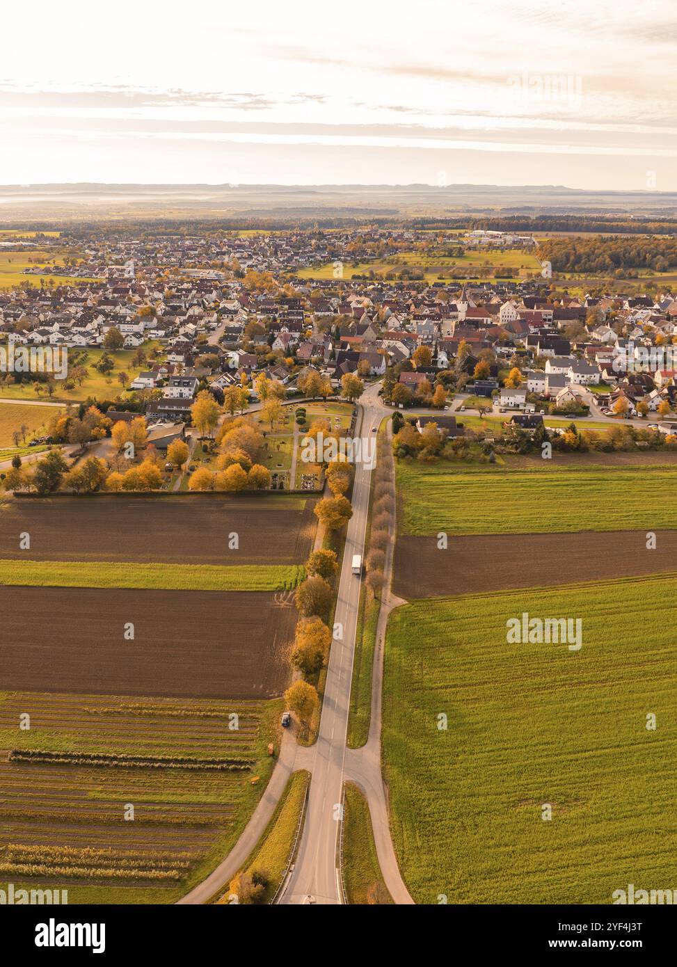 Veduta aerea di una piccola città con campi e una lunga strada in una calda luce autunnale, Jettingen, Foresta Nera, Germania, Europa Foto Stock