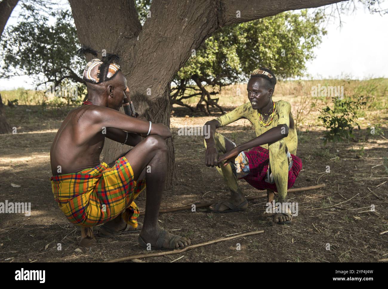 Due giovani con i tradizionali copricapo di argilla seduti su poggiatesta in legno convertiti in sgabelli, gruppo etnico Dassanetsch, Southern Omo Valley, Ethi Foto Stock