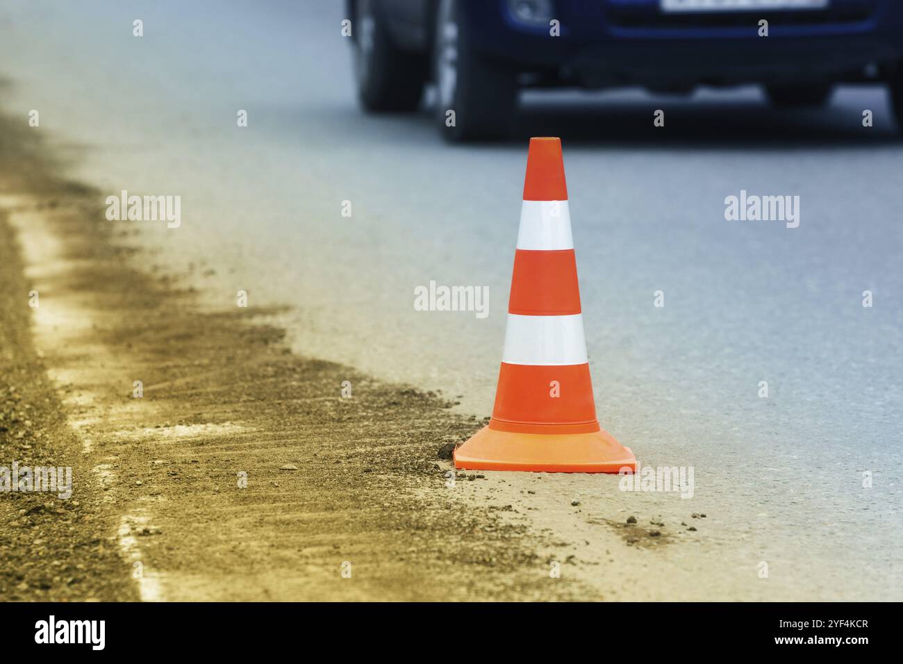 Avvertenza strada stradale cono si trova su strada asfaltata in città durante il restauro stradale, la riparazione stradale, lavori di pavimentazione asfaltata su autostrada automobilistica. Non riconosciuto Foto Stock
