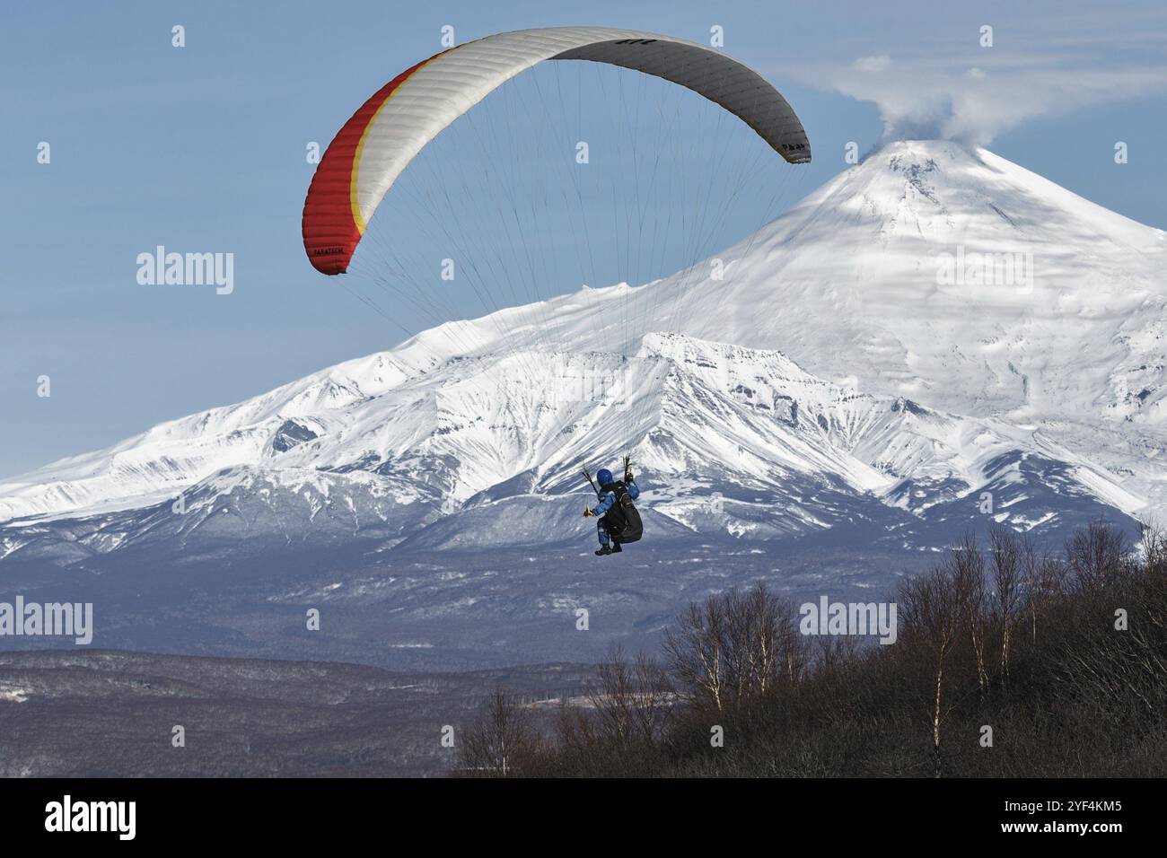 PENISOLA DI KAMCHATKA, RUSSIA, 21 NOVEMBRE 2014: Volo in parapendio sullo sfondo del vulcano Avachinsky attivo (vulcano Avacha) in una giornata di sole Foto Stock