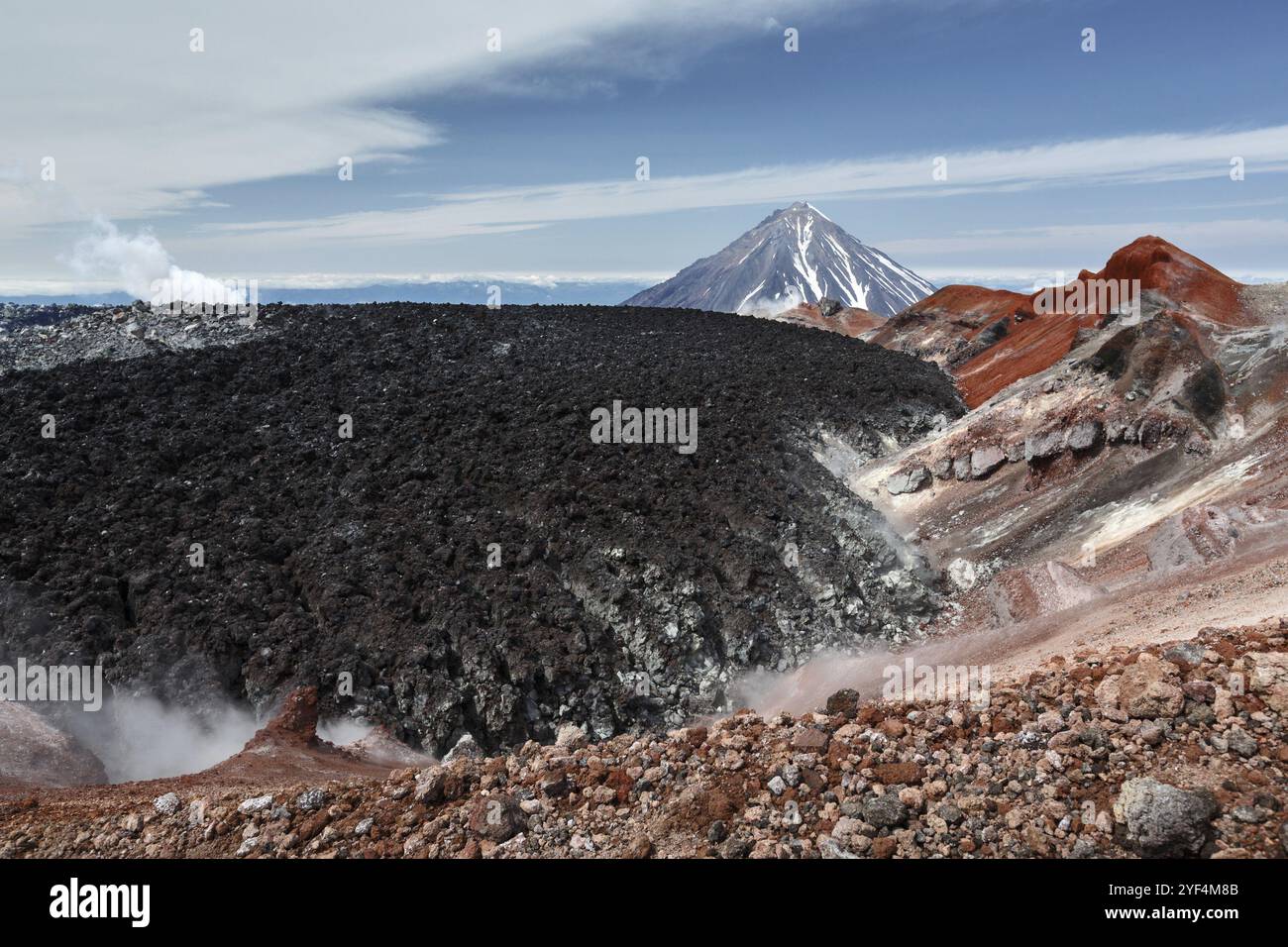 Paesaggio vulcanico estivo di Kamchatka: Splendida vista del cratere attivo Avachinsky sulla penisola di Kamchatka sullo sfondo del vulcano Koryak su un su Foto Stock