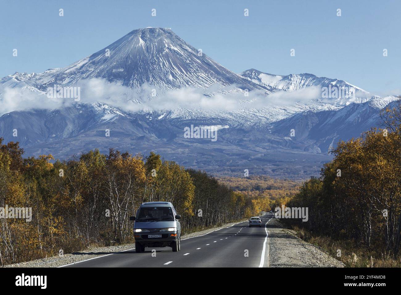 KAMCHATKA, RUSSIA, SEP 30, 2012: Vista autunnale delle auto sulla strada di guida verso l'attivo vulcano Avachinsky sulla penisola di Kamchatka in una giornata soleggiata e senza nuvole Foto Stock
