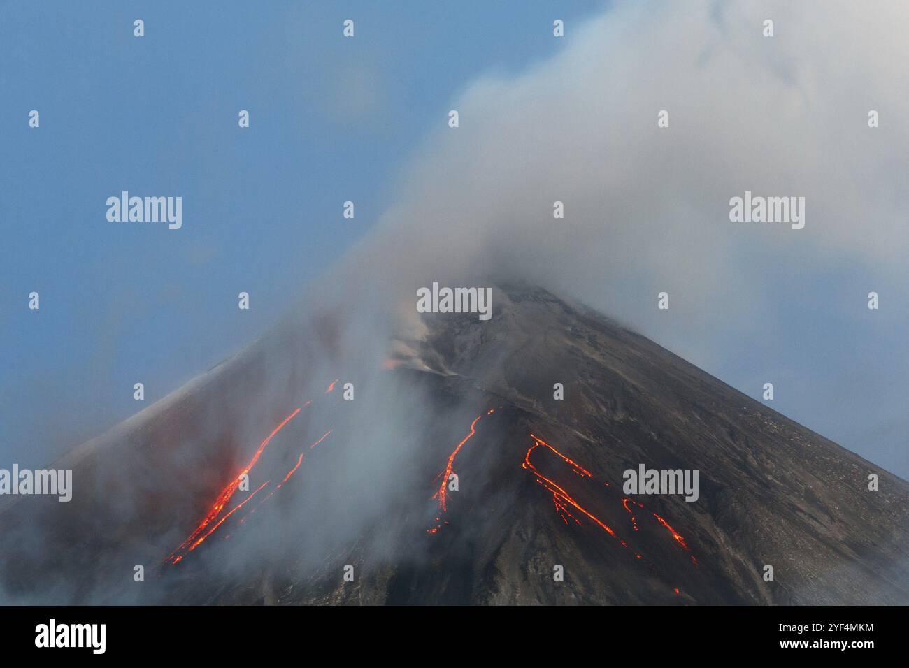 Paesaggio vulcanico della penisola di Kamchatka: Attivo Klyuchevskaya Sopka, vista della cima di un'eruzione vulcanica, flussi di lava sul pendio del vulcano, pennacchio di ga Foto Stock