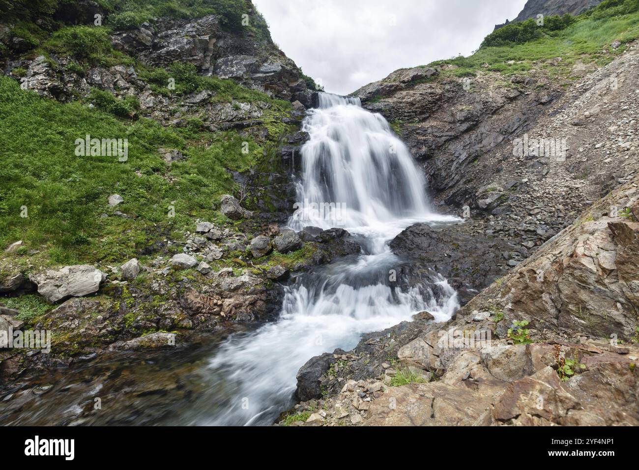 Paesaggio estivo della regione di Kamchatka: Splendida vista del fiume di montagna e della cascata nella catena montuosa Vachkazhets. Penisola di Kamchatka Russia far EA Foto Stock