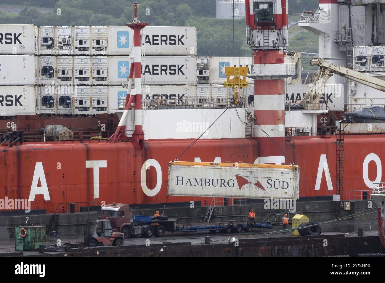 La gru scarica la nave portacontainer russa Sevmorput, un accendino rompighiaccio nucleare a bordo della nave portaerei. Terminal del porto marittimo commerciale. Oceano Pacifico, K. Foto Stock