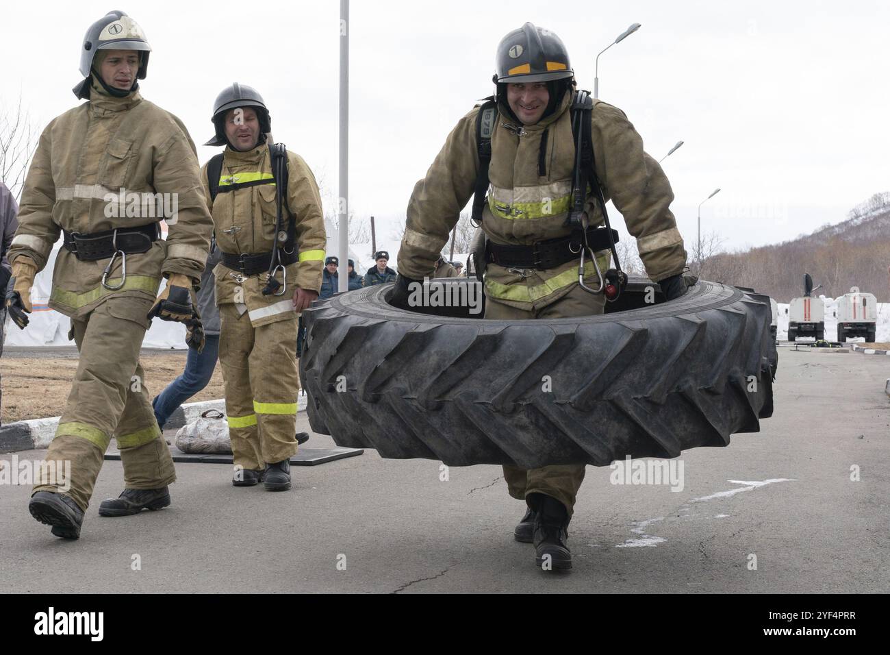 PETROPAVLOVSK CITY, PENISOLA DI KAMCHATKA, RUSSIA, 19 aprile 2019: Il forte pompiere-soccorritore Emercom della Russia trasporta grandi pneumatici dal camion. Vigili del fuoco Foto Stock