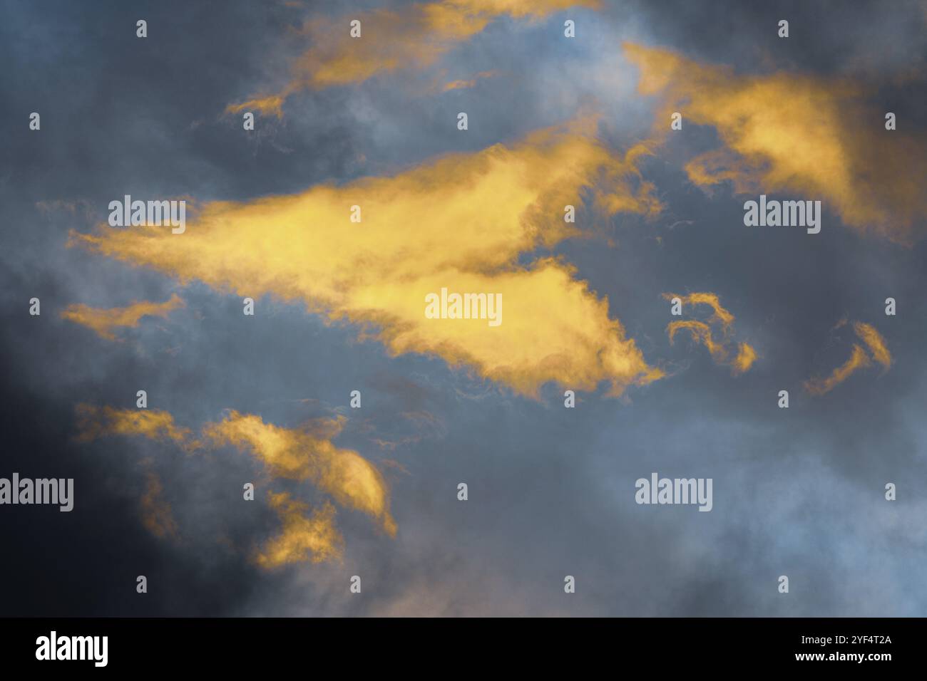 Golden Sunny soffici nuvole illuminate da raggi scompaiono al tramonto, cumulonimbus scuro galleggiare attraverso il cielo blu per cambiare stagione meteo. Vi sorprendente Foto Stock