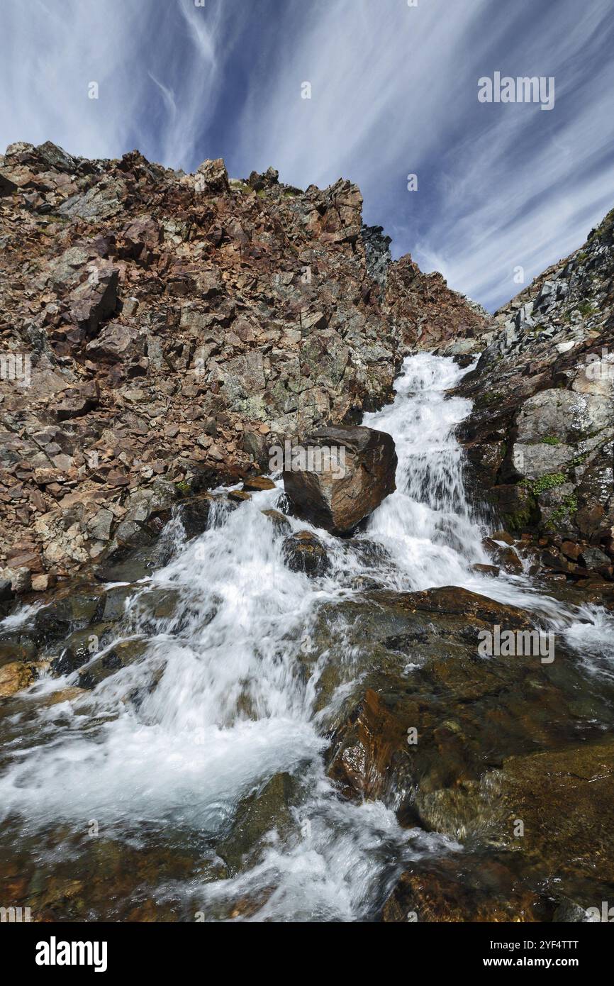 Splendido paesaggio montano estivo: Pittoresca vista del fiume di montagna sulle ripide scogliere su uno sfondo di cielo blu con nuvole su un soleggiato d Foto Stock