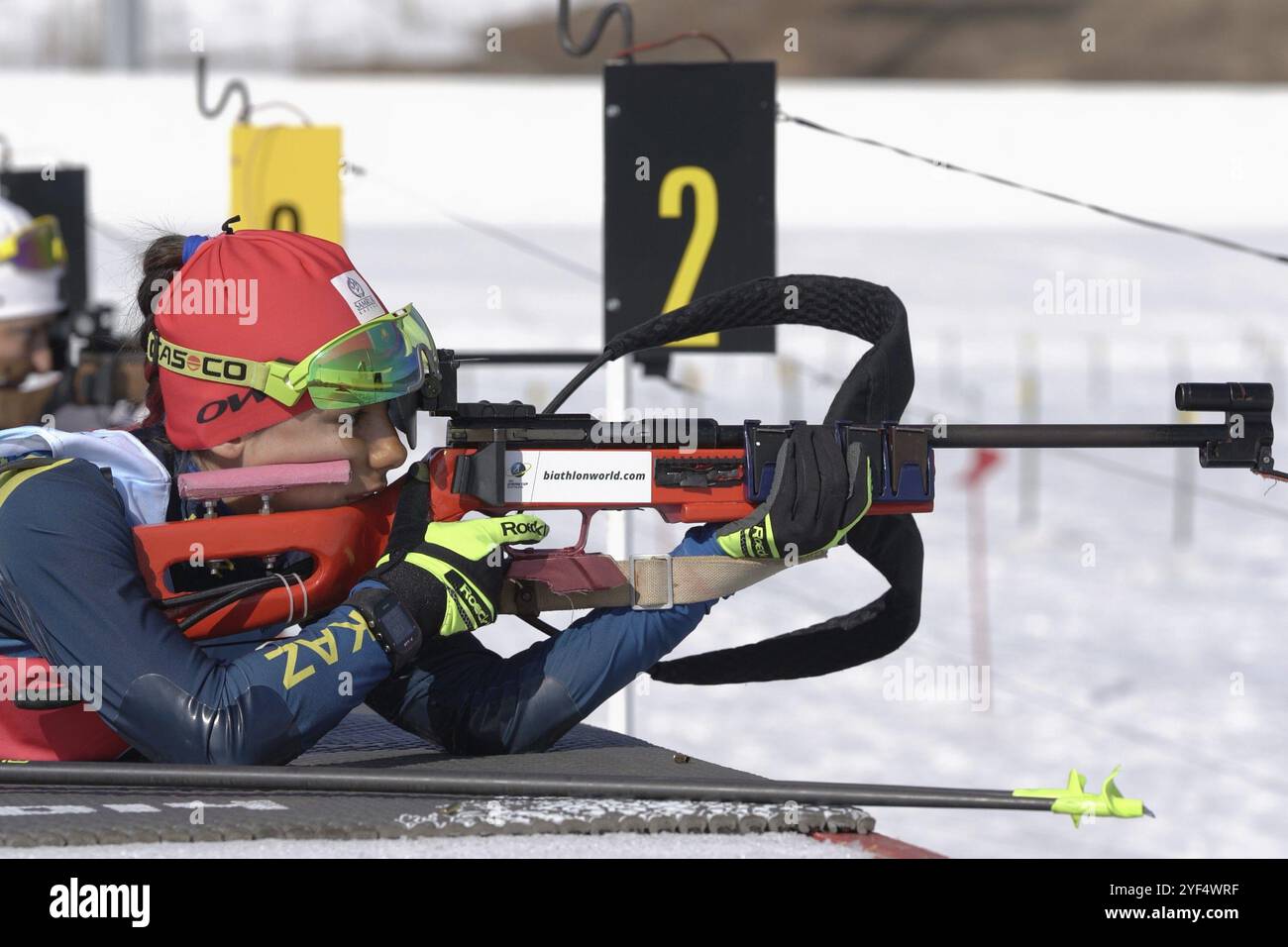 Puntamento biatleta sportiva, tiro al fucile, ricaricamento della posizione prona. Biatleta Polina Yegorova Kazakistan nel poligono di tiro. Junior biathlon compet Foto Stock