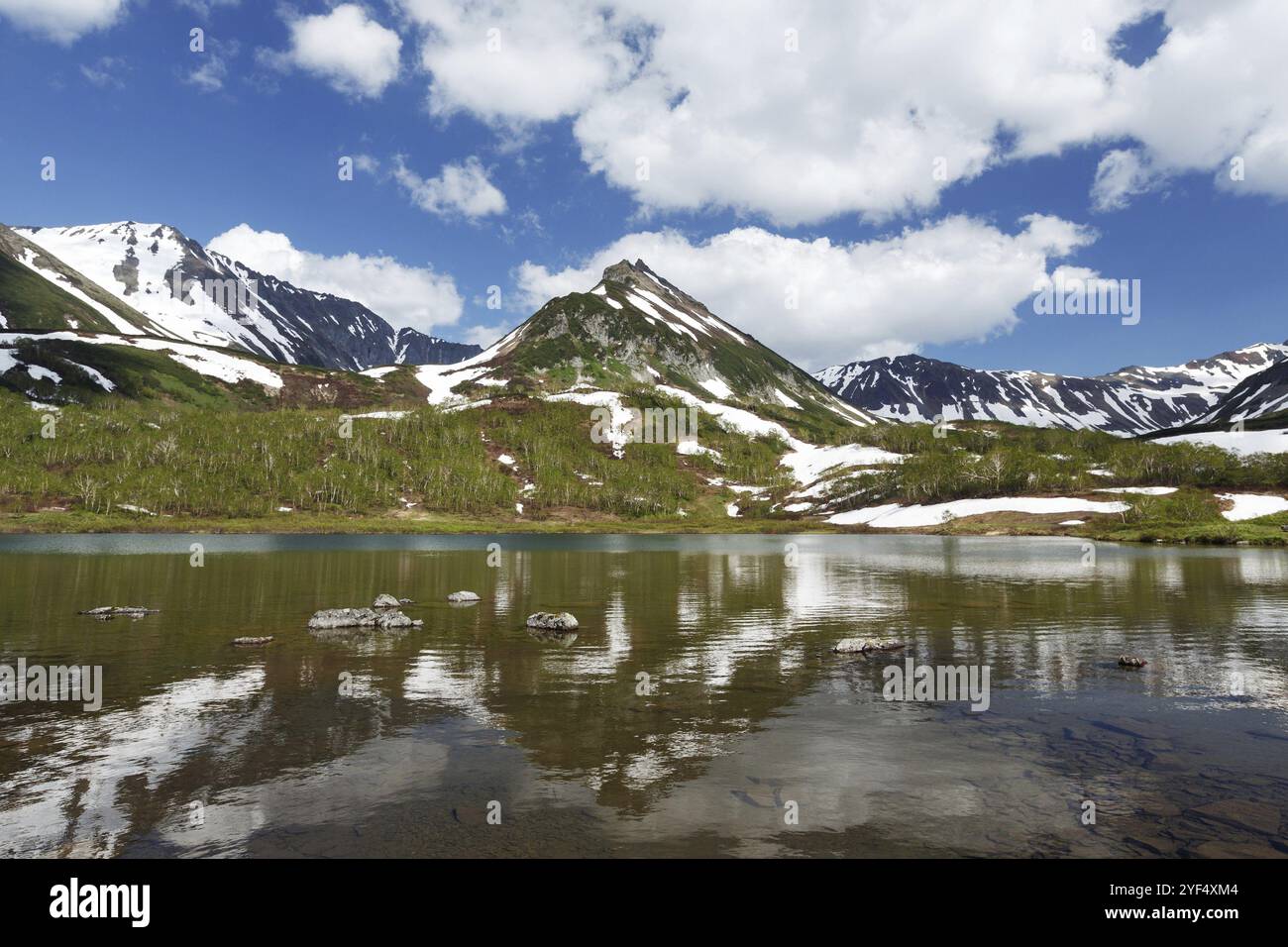 Paesaggio estivo di Kamchatka: Vista della catena montuosa Vachkazhets e nuvole nel cielo blu, riflesso nel lago di montagna nelle giornate di sole. Eurasia, Russia F Foto Stock