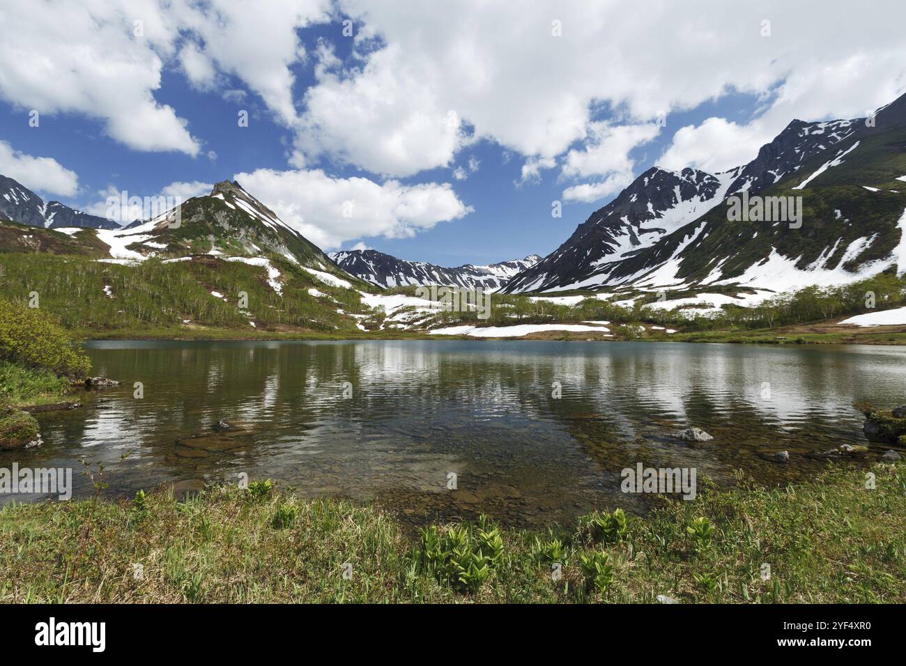 Scenario paesaggio estivo di Kamchatka: Splendida vista della catena montuosa Vachkazhets, lago di montagna e nuvole nel cielo blu nelle giornate di sole. Eurasia, russi Foto Stock