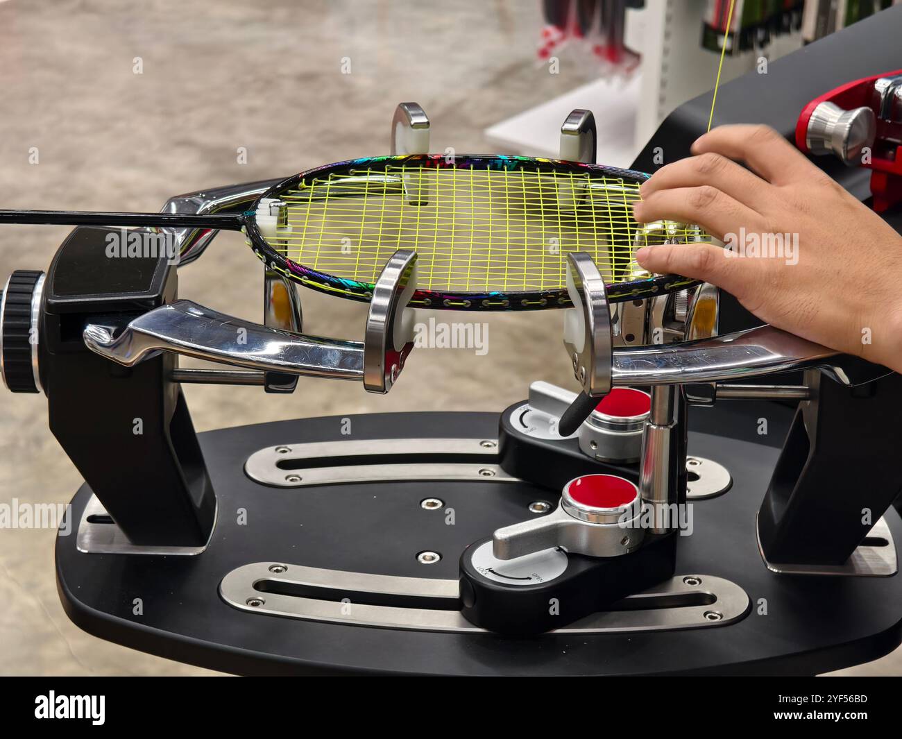 Indossa una racchetta da badminton su una macchina per stringere a racchetta. Foto Stock
