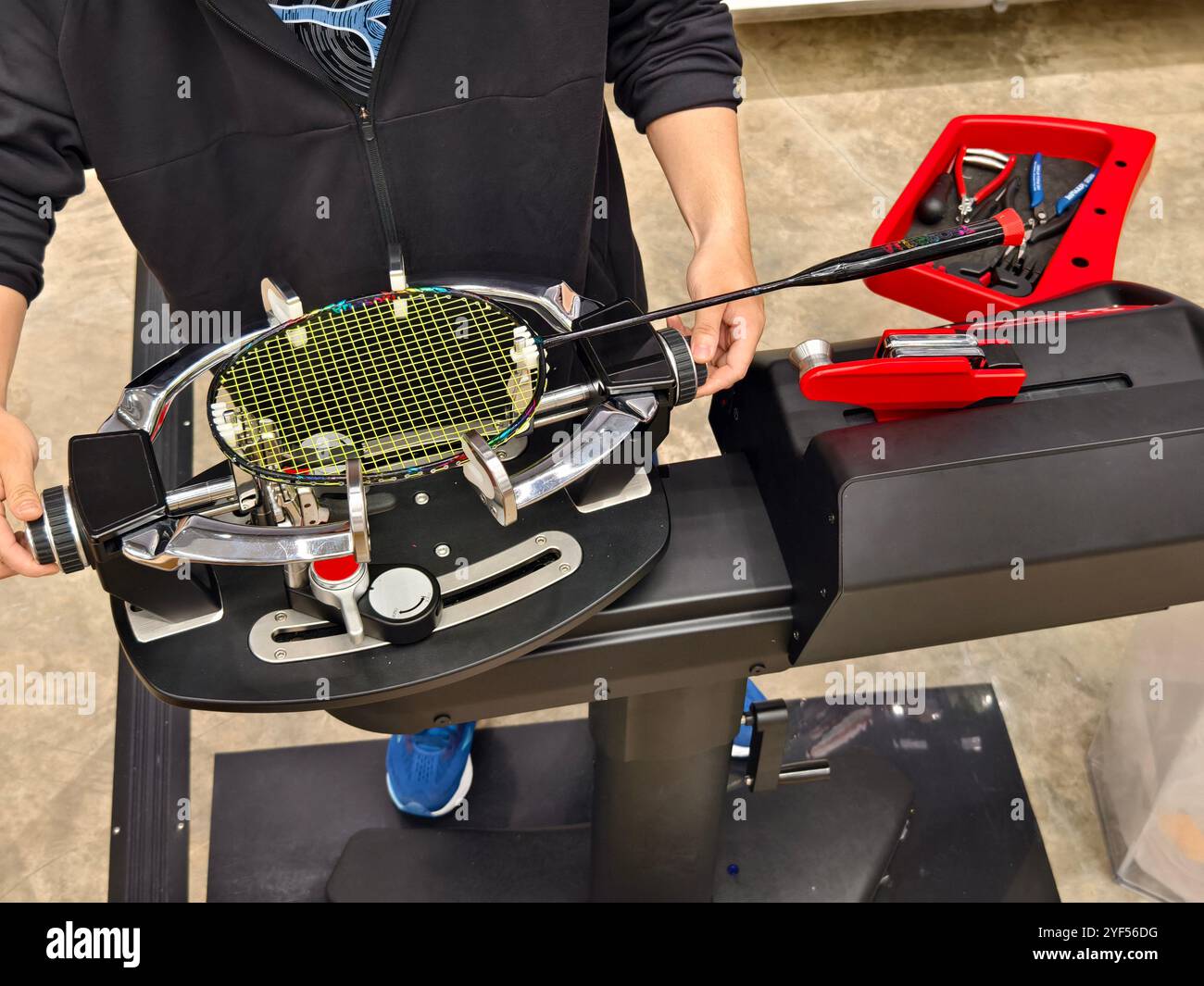 Indossa una racchetta da badminton su una macchina per stringere a racchetta. Foto Stock
