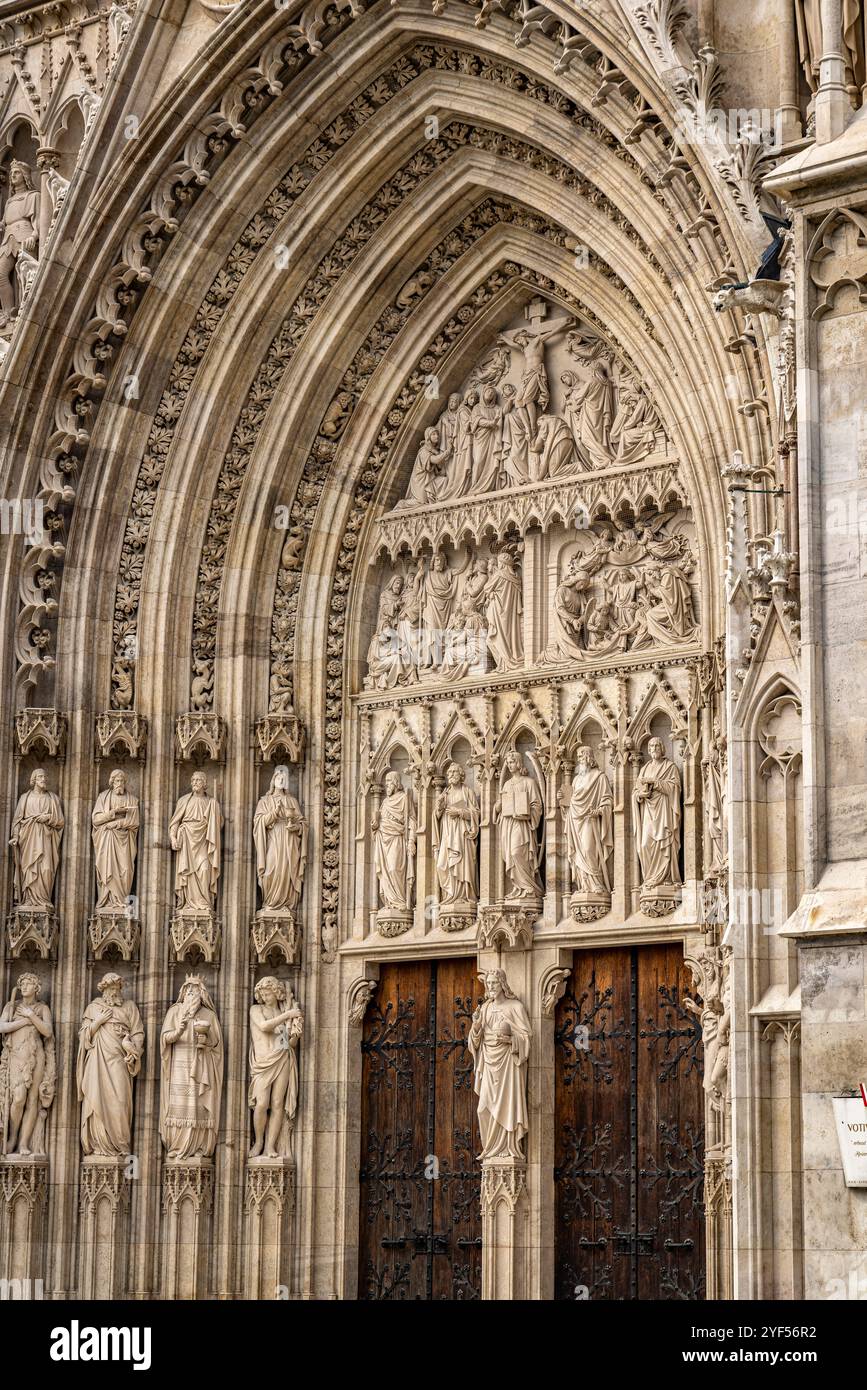 Intricati lavori in pietra all'ingresso della Votivkirche, Vienna, Austria, Europa. Foto Stock