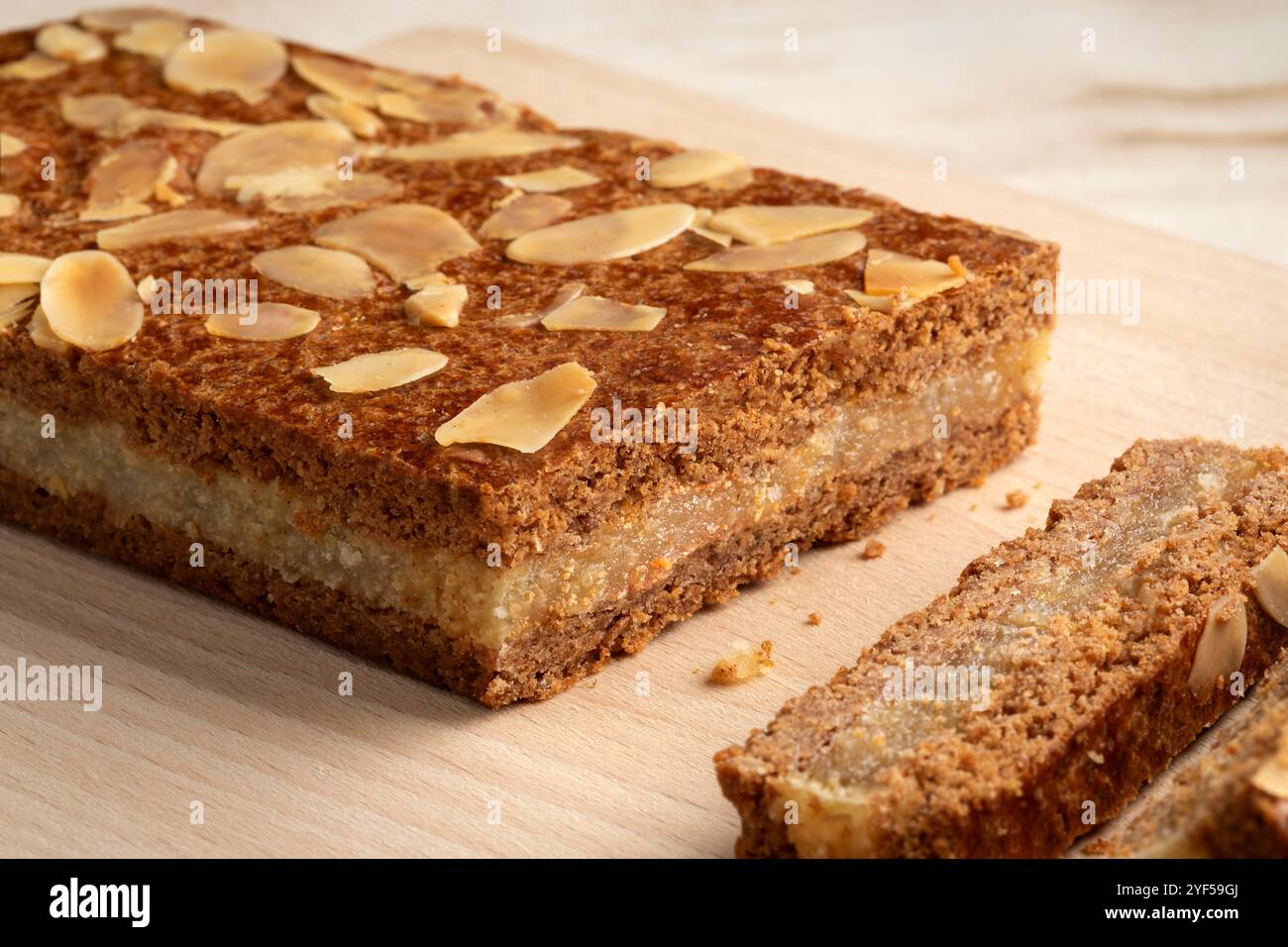 Pezzo di tipico dolce olandese chiamato gevulde speculaas e fette da servire alla sera di Sinterklaas su un tagliere da vicino Foto Stock