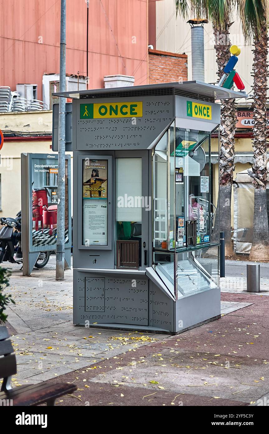 Viladecans. Spagna - 3 novembre 2024: Vista sulla strada di un chiosco della lotteria con cartellonistica Braille, pannelli di vetro e poster promozionali. Il chiosco è S. Foto Stock