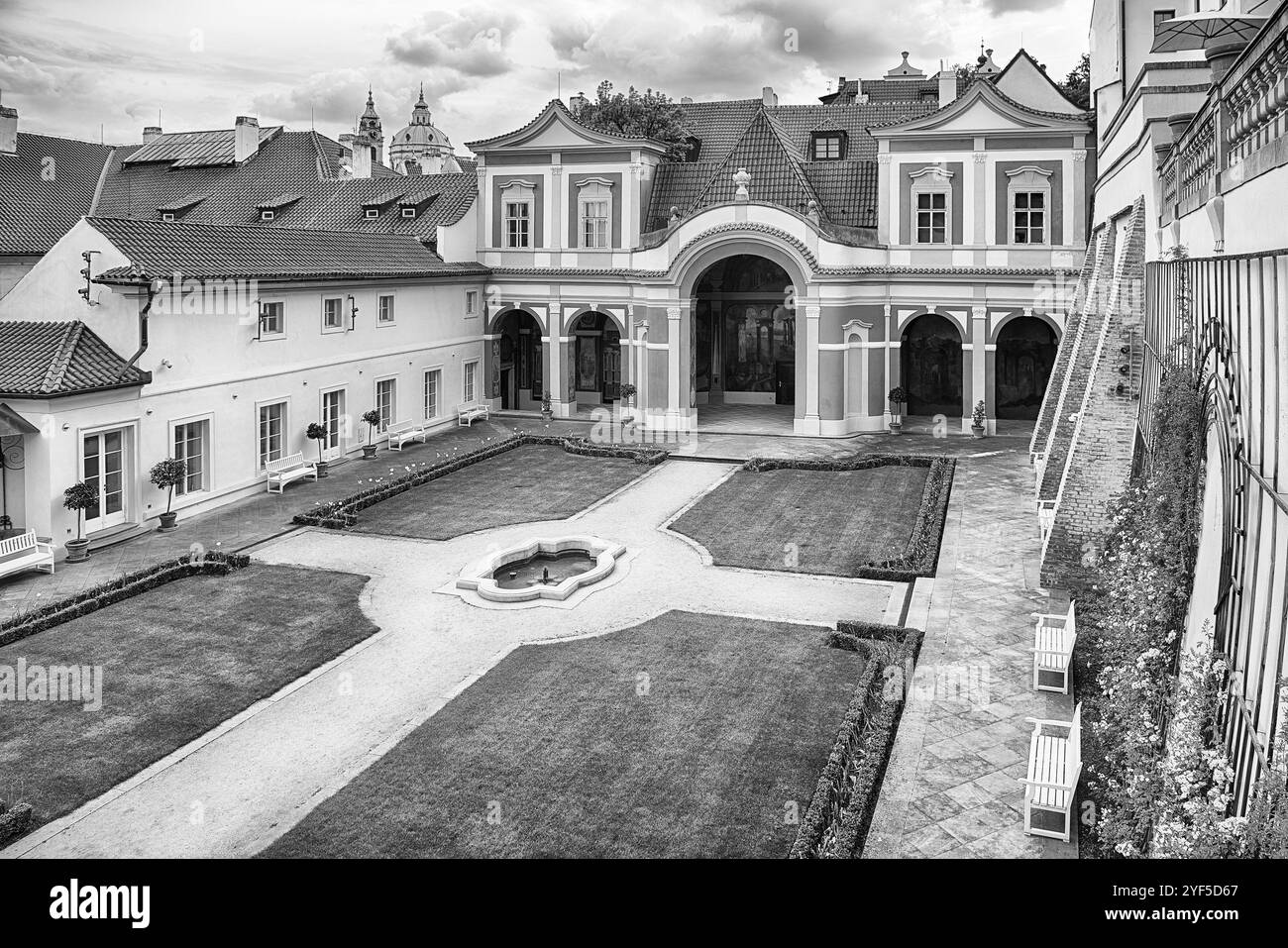 PRAGA - 11 MAGGIO 2024: Sereno giardino con prati curati, una fontana centrale e sentieri, racchiusi da eleganti edifici barocchi all'interno dei Giardini belo Foto Stock