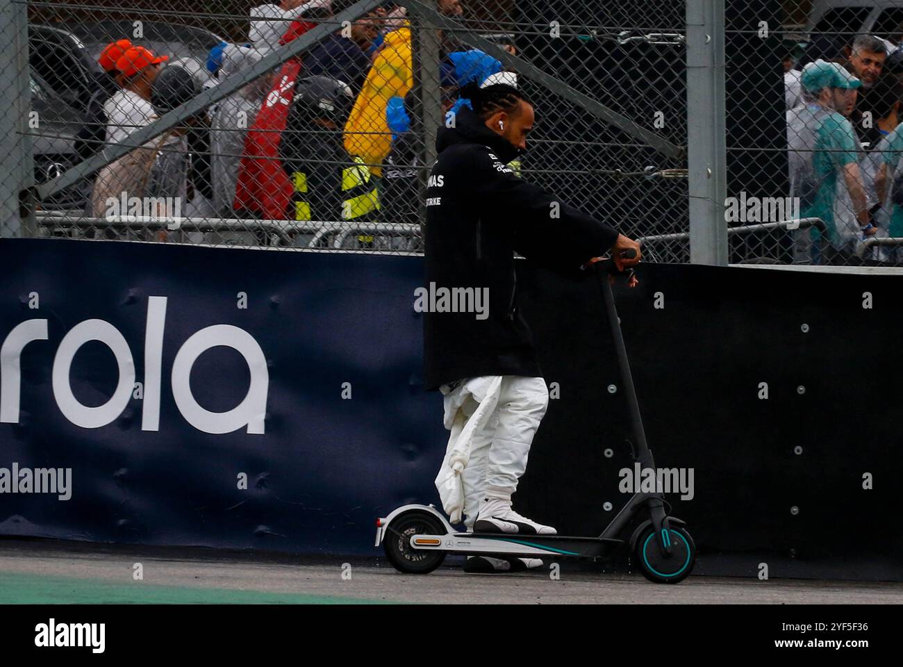 São PAOLO, SP - 03.11.2024: TREINO CLASSIFICAT'RIO GP F1 LENOVO SP - si svolge questa domenica (03) sul circuito di Interlagos, a sud della capitale di São Paolo, dopo essere stato rinviato a causa della pioggia pesante che è caduta questo sabato (02), la formazione di qualificazione per il Gran Premio Lenovo di Formula 1 di São Paolo 2024. Nella foto, in omaggio all'ex pilota brasiliano Ayrton Senna. Il pilota, Lewis Hamilton #44, MERCEDES, si dirige verso la McLaren MP4/5, due volte campionato del mondo, utilizzando uno scooter. (Foto: Aloisio Mauricio/Fotoarena) Foto Stock