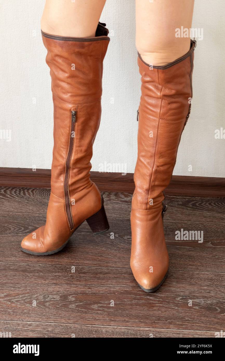 Donna magra che indossa eleganti stivali stretti in pelle Foto Stock