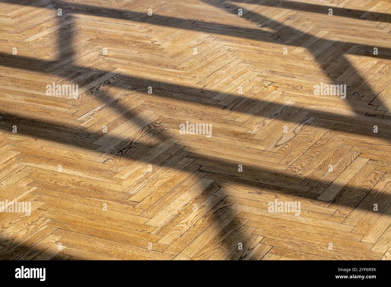 Sfondo astratto con ombre diritte da una cornice della finestra su un vecchio piano in parquet di legno. Foto Stock