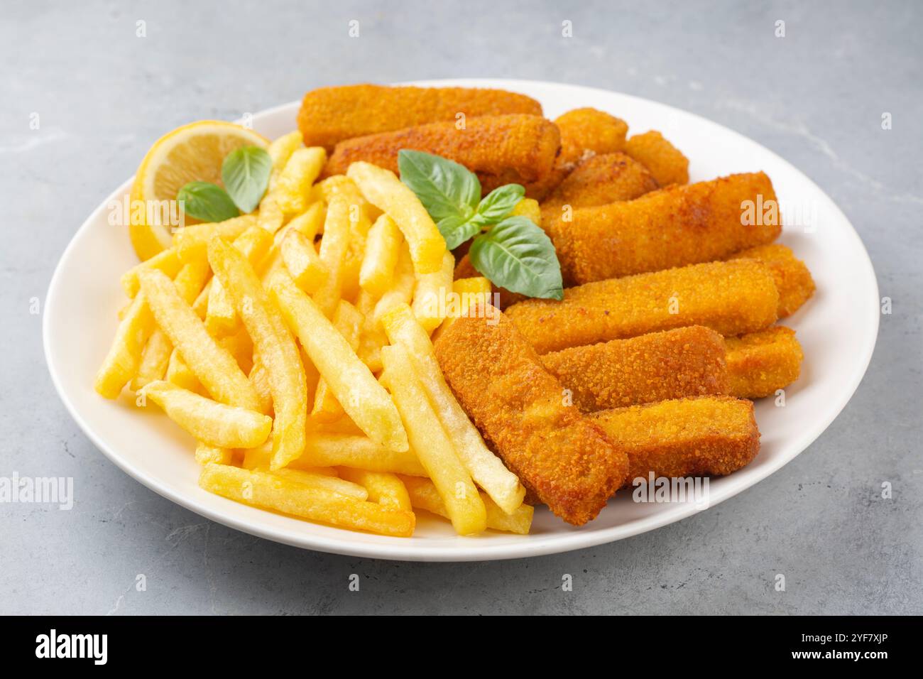Fish and chips . Primo piano di bastoncini di pesce fritti e croccanti con pangrattato serviti con salsa remoulade e limone Foto Stock