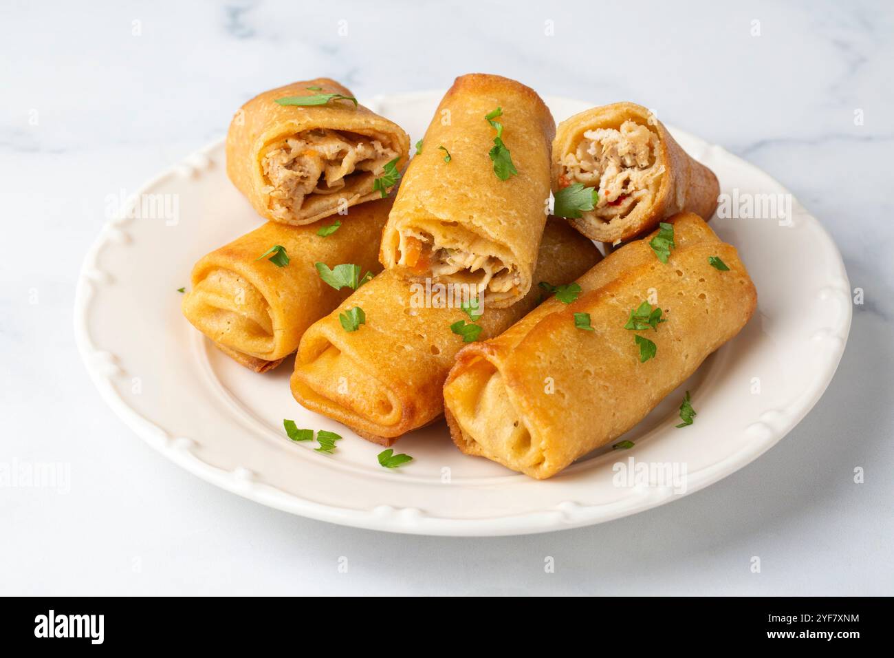 Frittelle o crepe sottili ripiene di pollo e funghi su un piatto Foto Stock