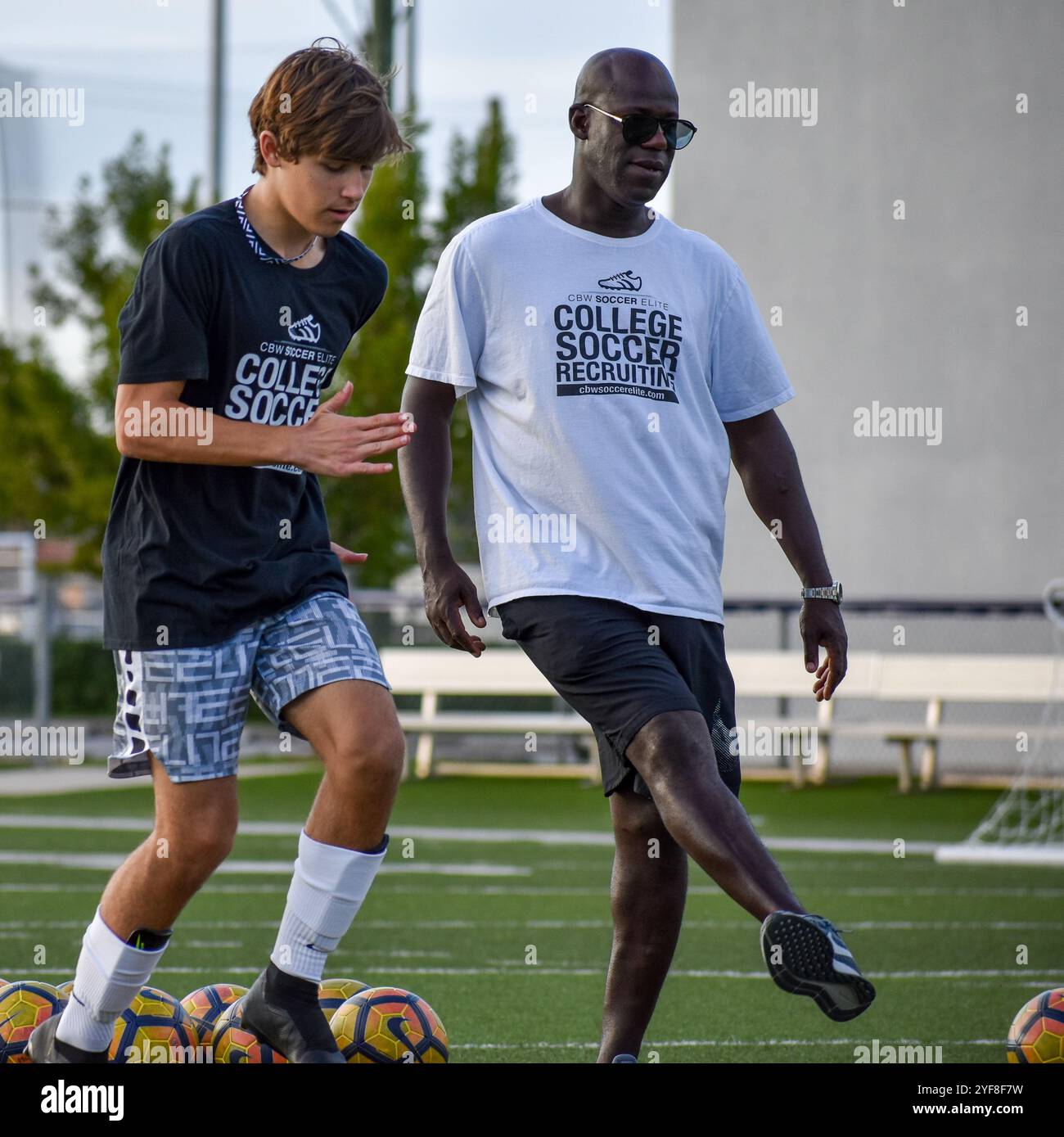 La leggenda della Premier League Chris Bart-Williams allena un giovane atleta a giocare a calcio universitario Foto Stock