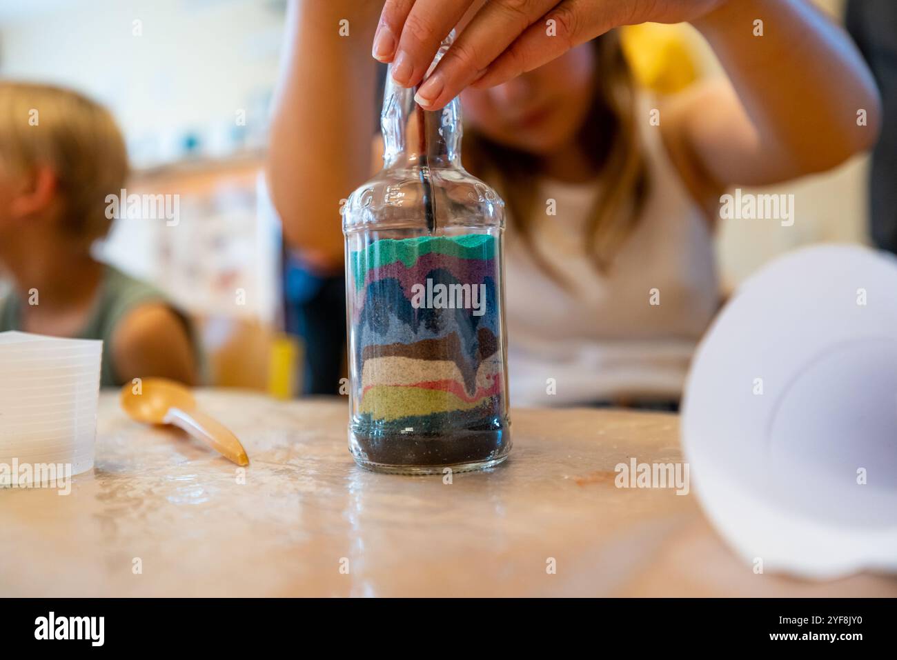 Sabbia colorata in una bottiglia di vetro, uno strumento terapeutico ideale per i bambini Foto Stock