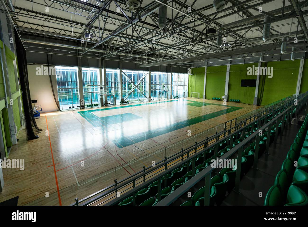 Struttura sportiva moderna con campo multisportivo, posti a sedere e grandi finestre Foto Stock