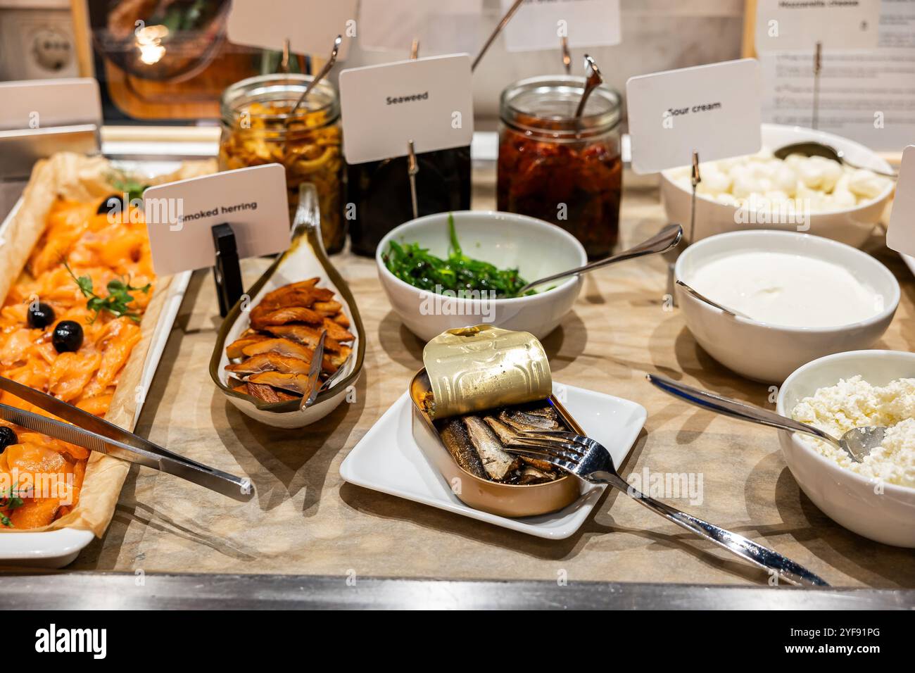 Selezione di colazioni gourmet con pesce affumicato e condimenti in mostra Foto Stock