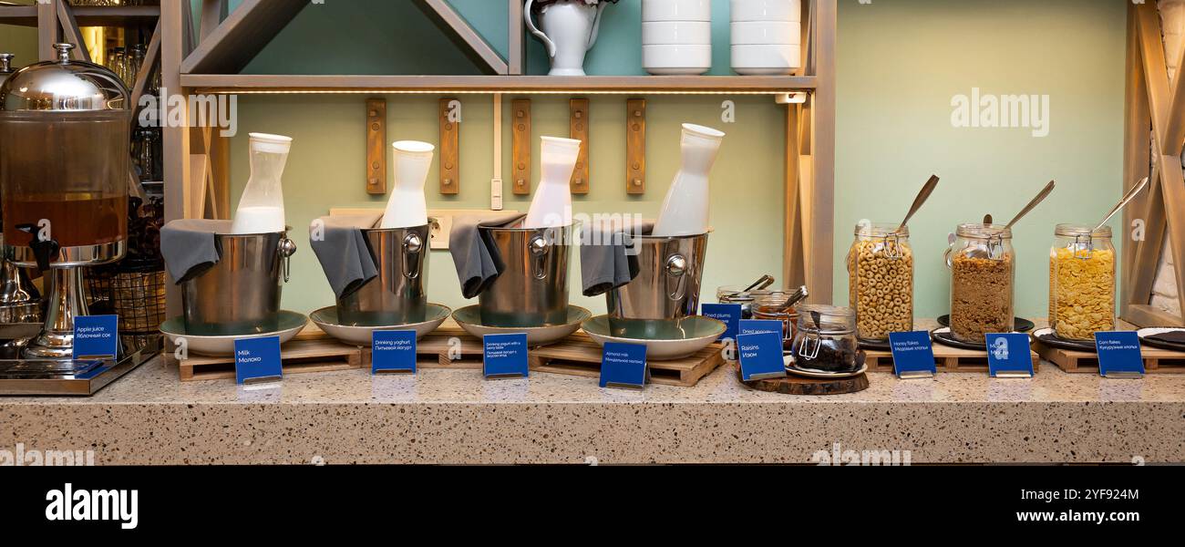 Elegante colazione a buffet con cereali e latte in un ambiente moderno in hotel Foto Stock