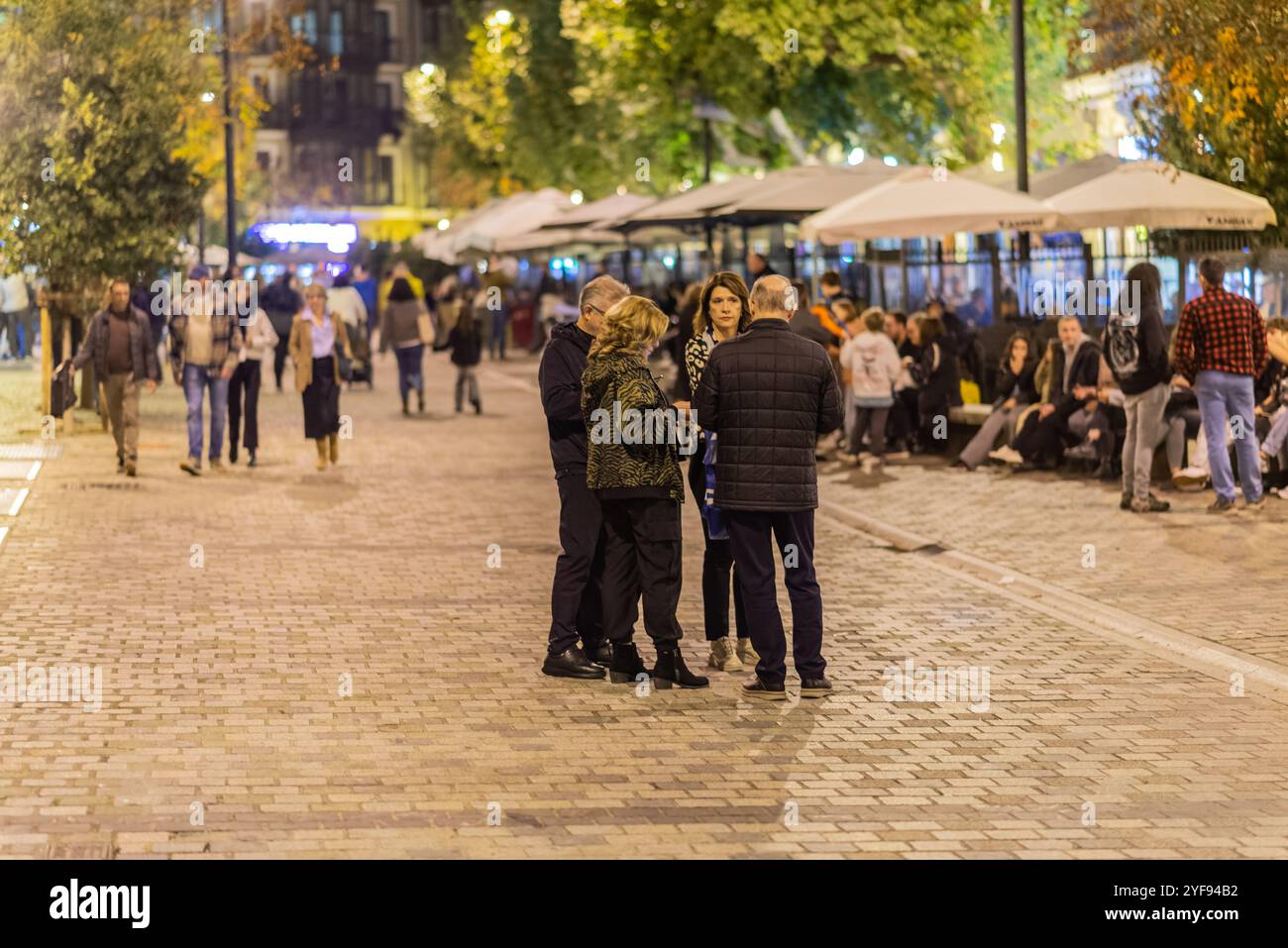 Logroño, la Rioja, Spagna. 2 novembre 2024. Persone che camminano lungo la strada pedonale acciottolata durante la notte autunnale. Foto Stock