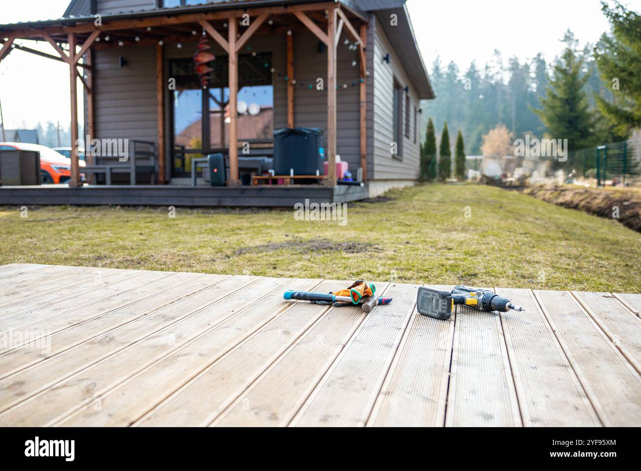 Utensili disposti su un nuovo pavimento in legno in un cortile durante un progetto di ristrutturazione di case fai da te Foto Stock