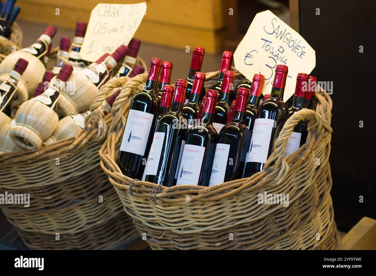 FIRENZE, ITALIA - 19 SETTEMBRE 2017: Bottiglie di vino rosso secco toscano in un cestino di vimini. Il mercato cittadino di Firenze Foto Stock