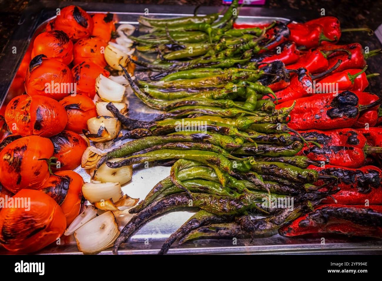 Un piatto di paprika alla griglia e pomodori, condito con erbe e spezie, splendidamente presentato su un piatto bianco in un ambiente di lusso. Perfetto per Foto Stock