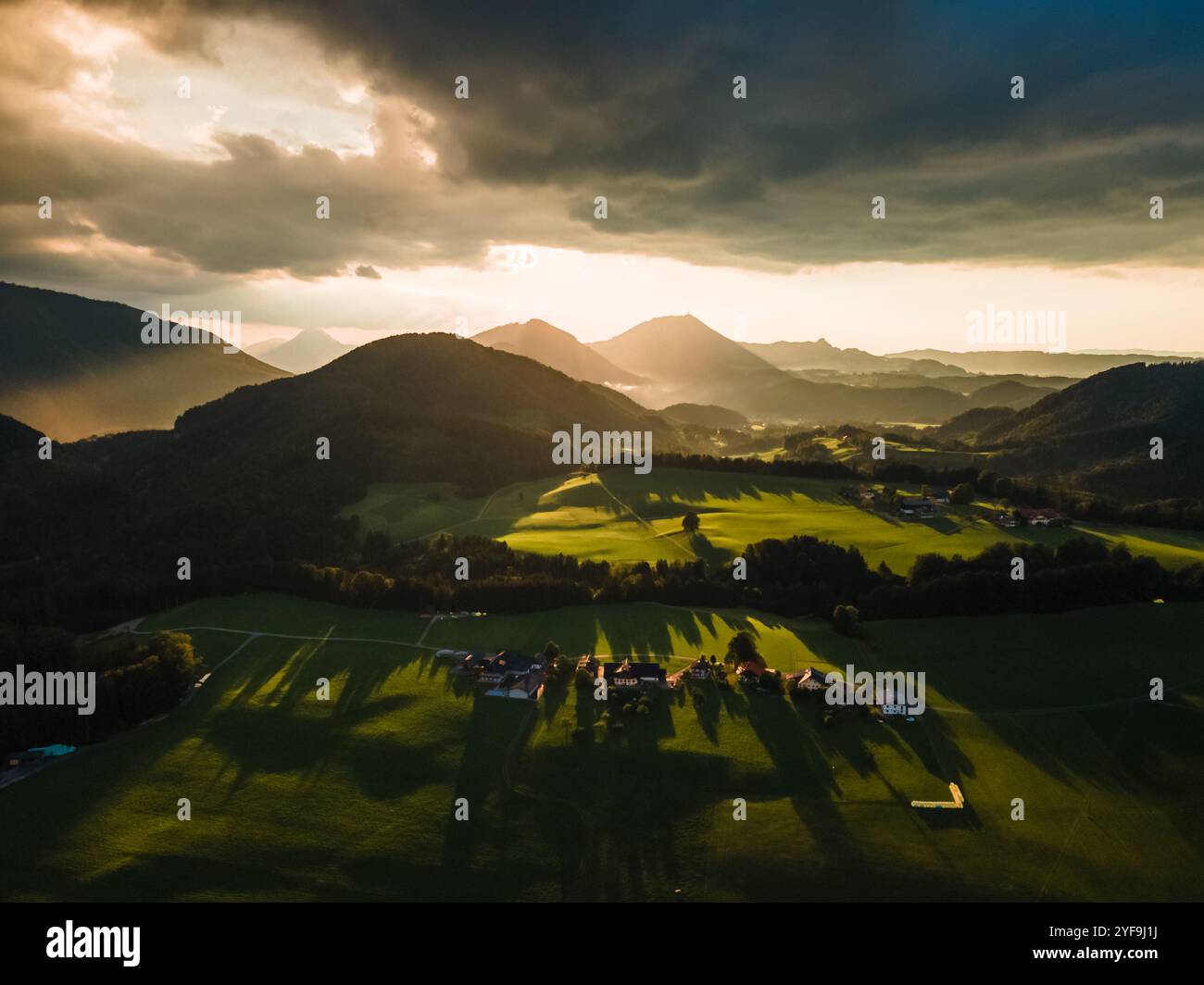 Tramonto d'oro che proietta una luce calda sulle Rolling Hills nella campagna austriaca Foto Stock