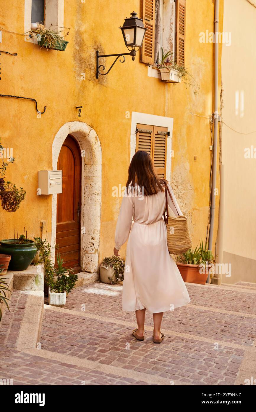 Vista posteriore di una donna in piedi vicino al vecchio edificio in strada Foto Stock