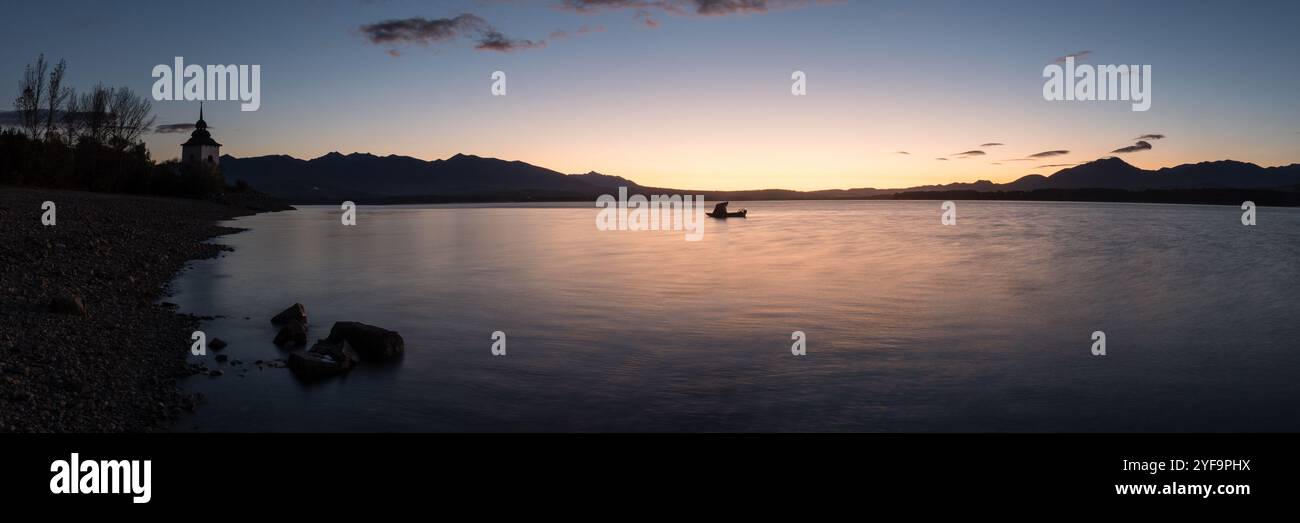 Vista mattutina della diga di Liptovska Mara con la Torre della Chiesa della Vergine Maria e la barca da pesca, la regione di Liptov, Slovacchia Foto Stock