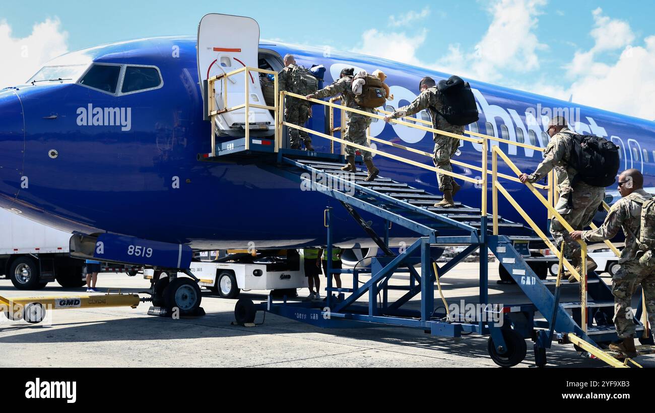 Soldati statunitensi assegnati alla 755th Military Police Company della 92nd Military Police Brigade, Guardia Nazionale dell'Esercito di Porto Rico, imbarcati su un aereo all'Aeroporto Internazionale Luis Muñoz Marín, San Juan, Porto Rico, 3 novembre 2024. Il 755th MP Co. Si mobilitò in Honduras per fornire sicurezza di base e sostegno alle operazioni umanitarie in tutta l'America centrale. (Foto della Guardia Nazionale dell'Esercito degli Stati Uniti di SPC. Felix Ortiz Rivera) Foto Stock