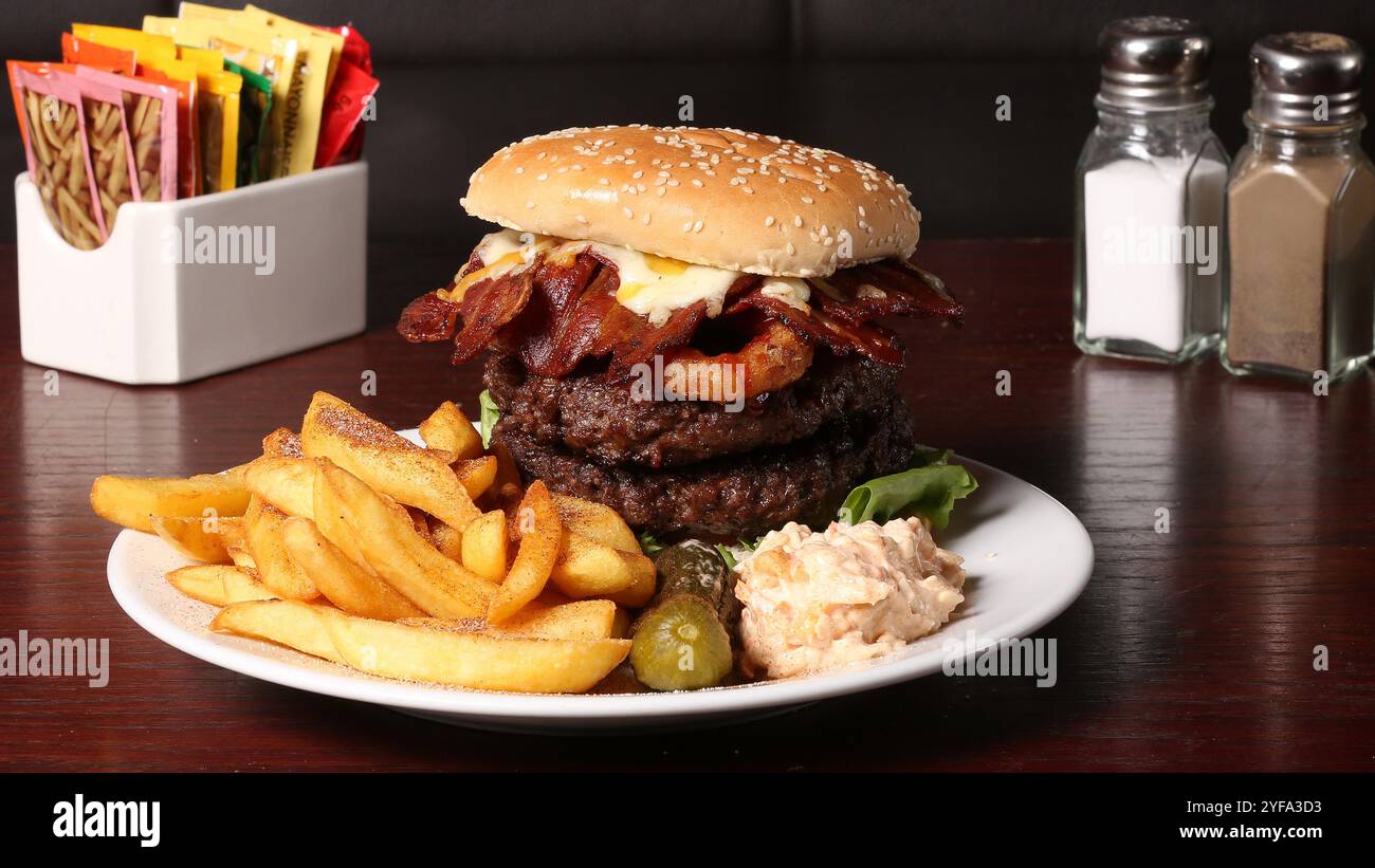 Hamburger e patatine su un piatto in un pub Foto Stock