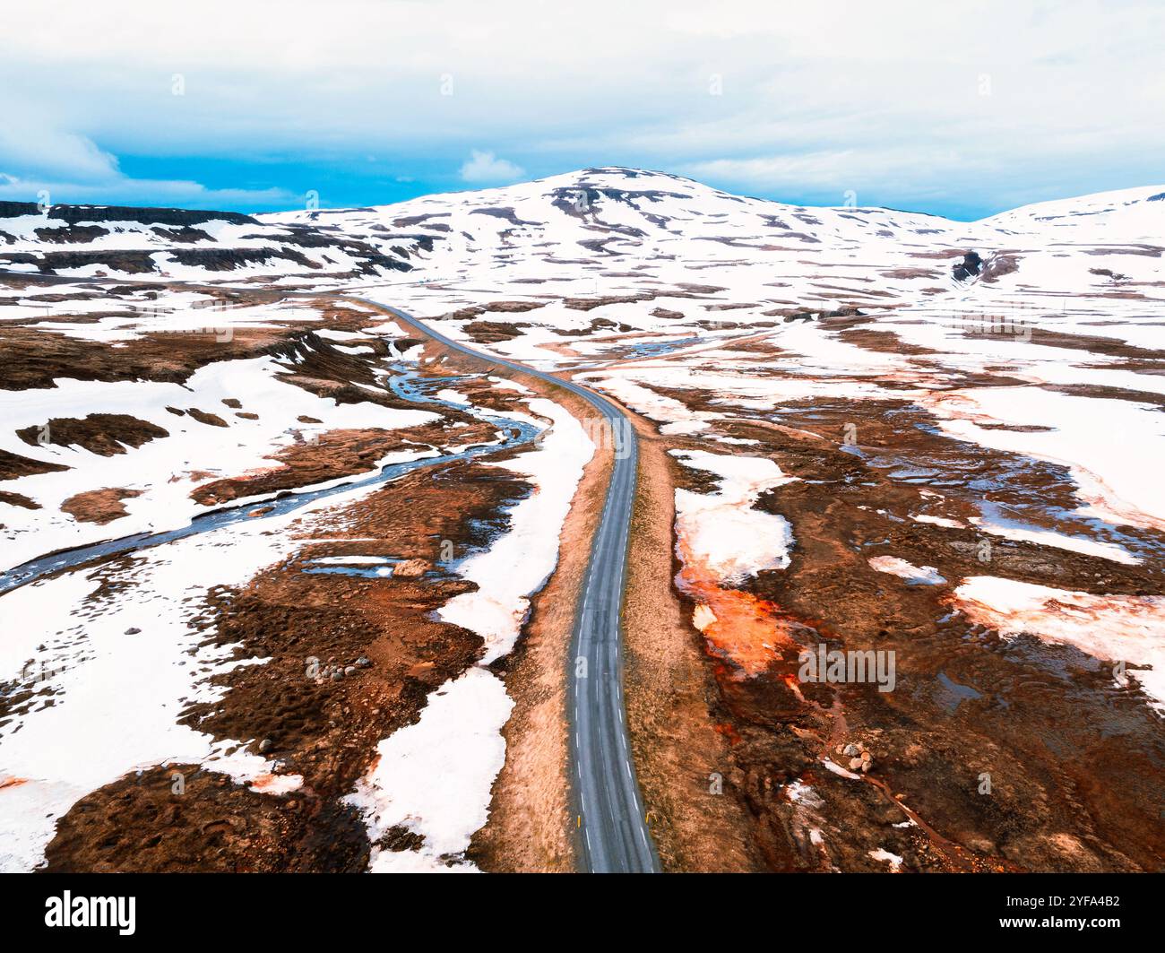 Splendida vista aerea del paesaggio spettacolare dell'Islanda, con montagne innevate e un fiume che si snoda attraverso una vallata aspra. Foto Stock
