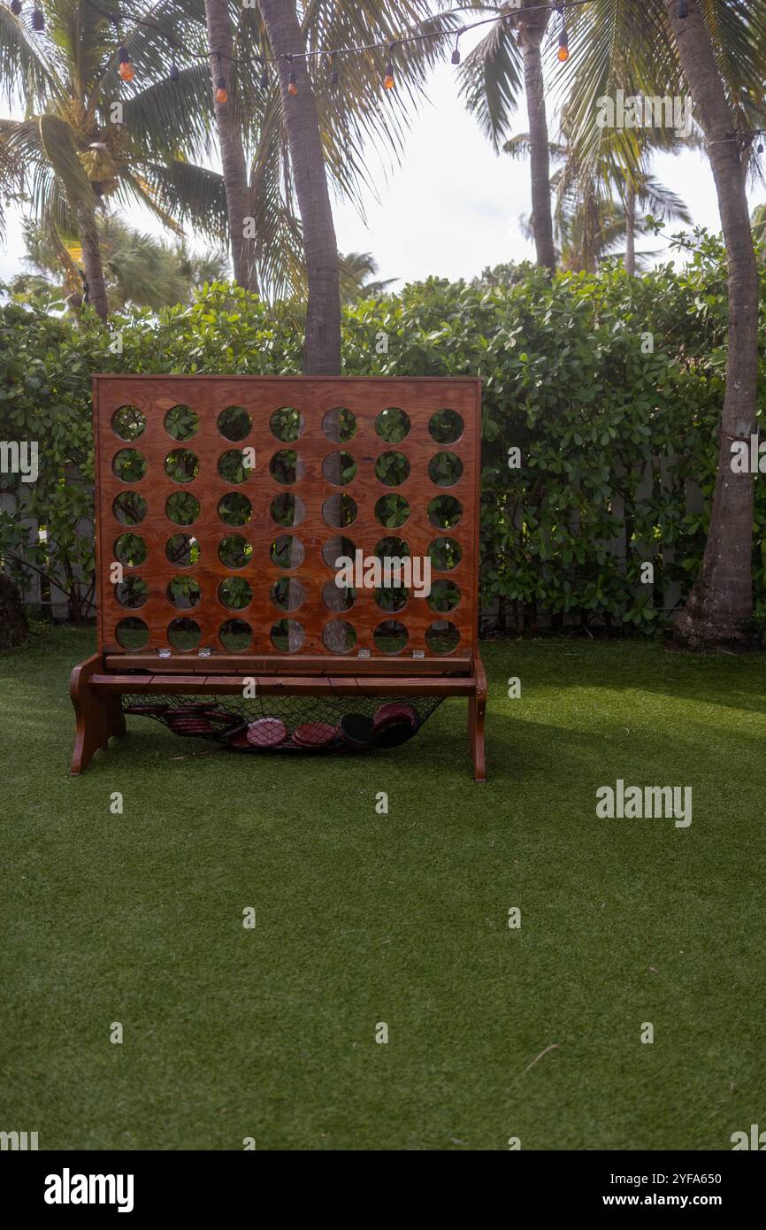 Grande set di gioco in legno Connect quattro su erba artificiale con palme Foto Stock