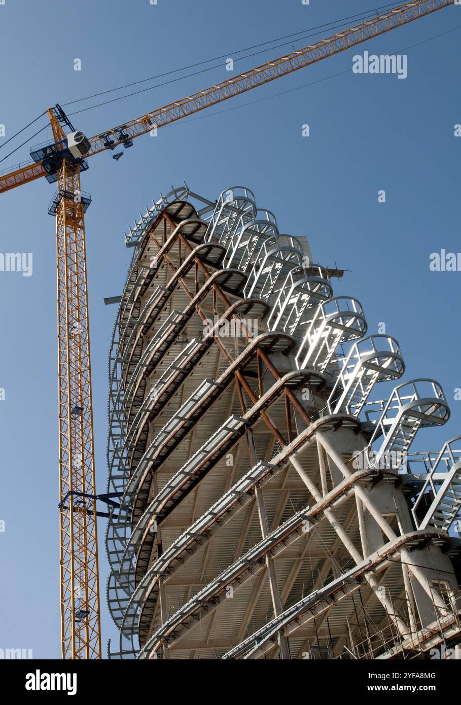 Moderna costruzione di grattacieli con gru gialla in una giornata di cielo azzurro Foto Stock