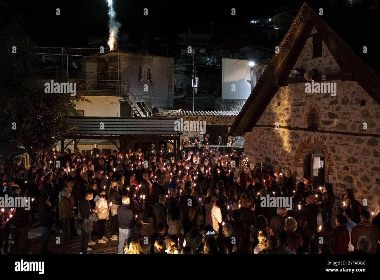 Nicosia, Cipro, 23 aprile 2022: Folla di religiosi che tengono candele e pregano fuori dalla chiesa cristiana durante la celebrazione della Santa Pasqua ortodossa Foto Stock