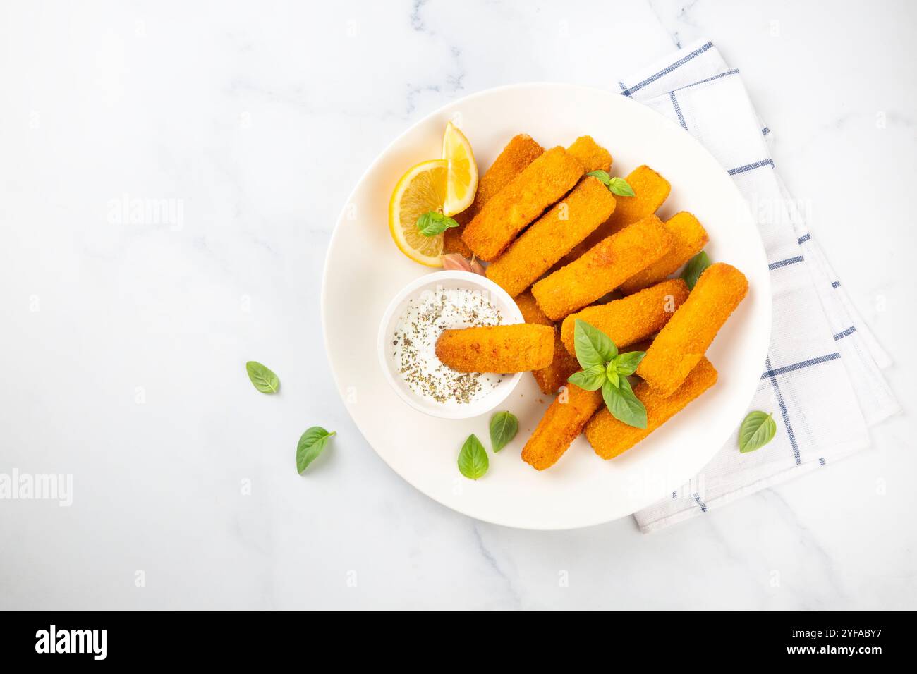 Fish and chips . Primo piano di bastoncini di pesce fritti e croccanti con pangrattato serviti con salsa remoulade e limone Foto Stock